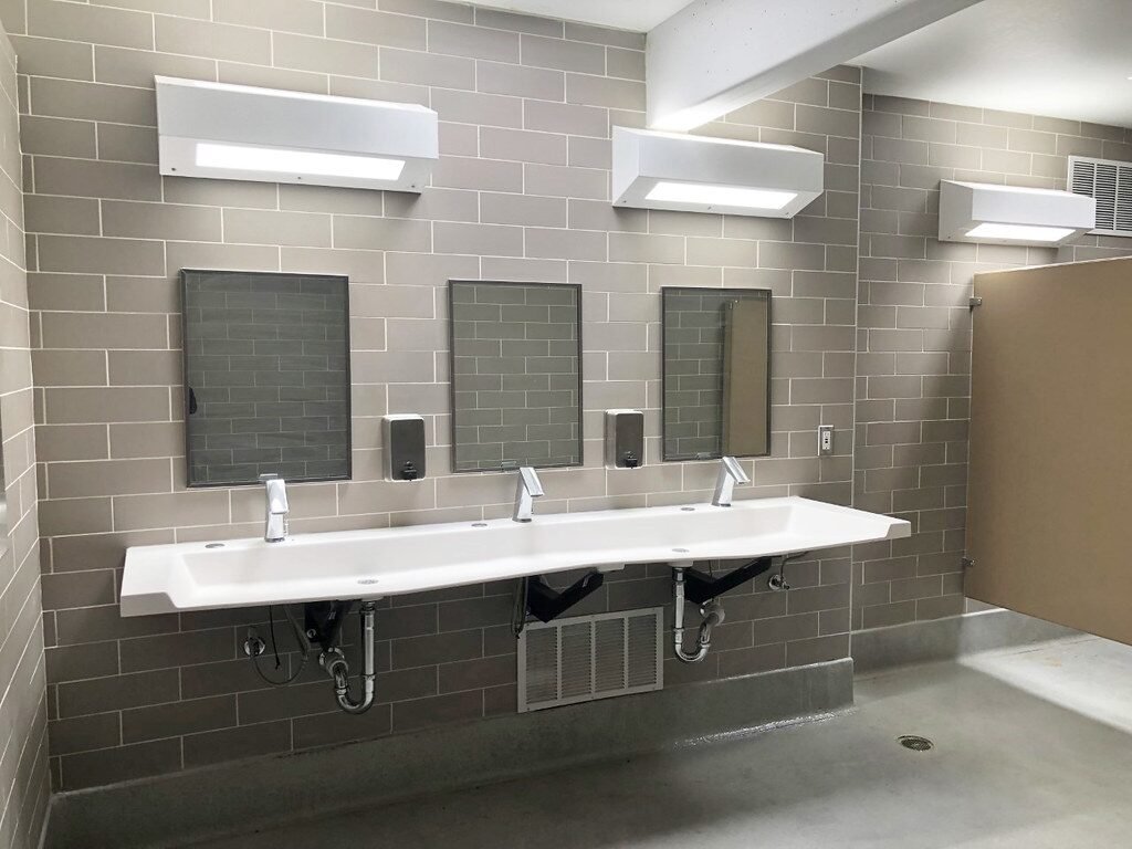 A row of washroom sinks and mirrors